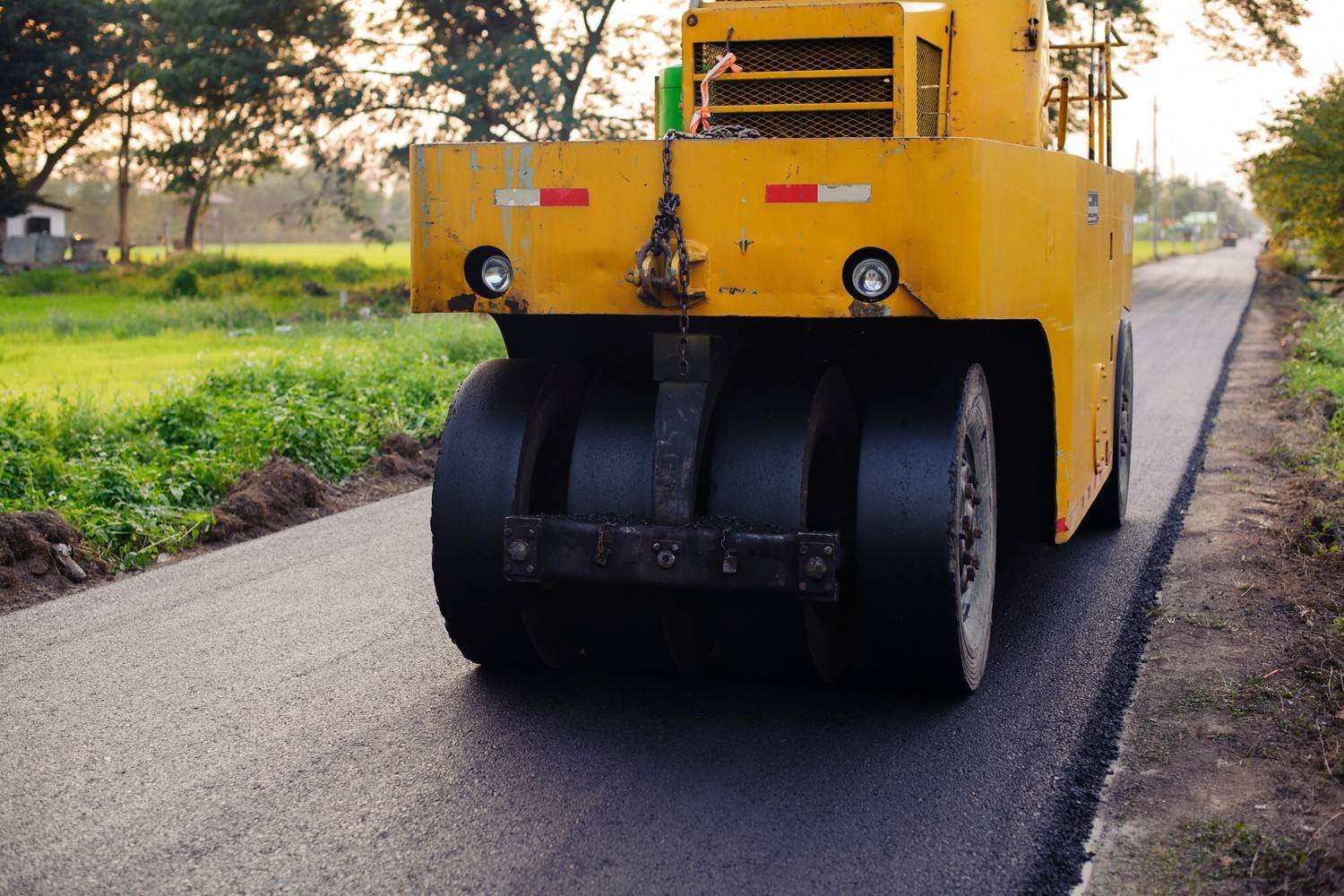 Asphalt roller compacting a new commercial parking lot surface