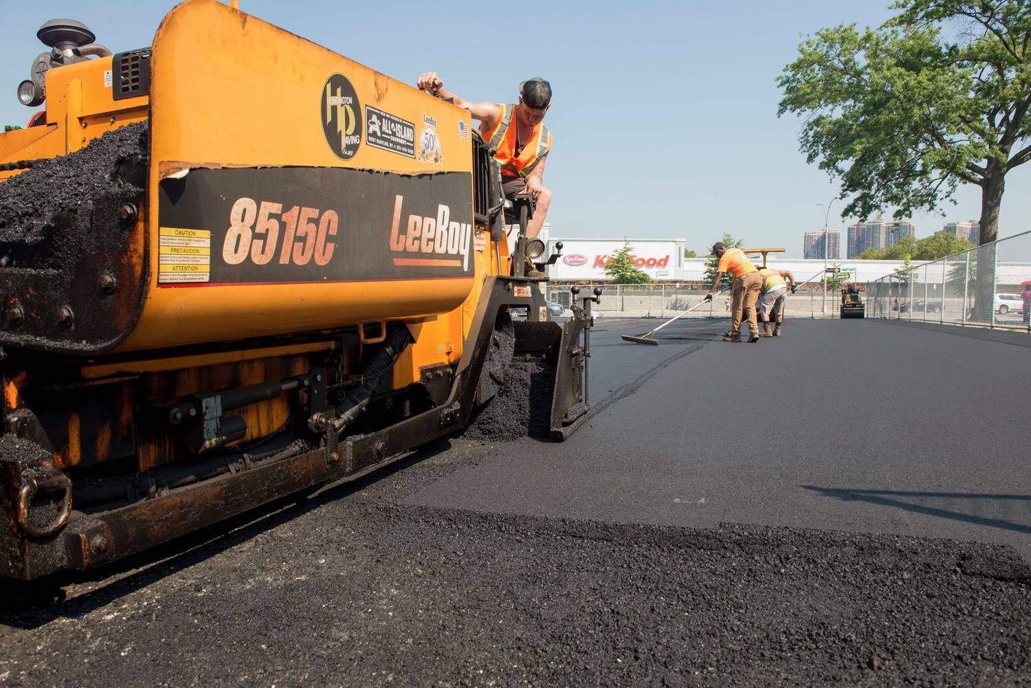 Commercial asphalt paving crew operating a LeeBoy 8515C paver on a parking lot project in Bridgeport.