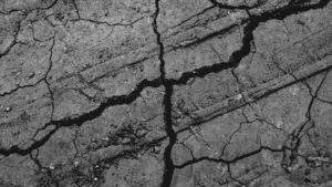 cracked commercial sidewalk showing freeze-thaw damage.